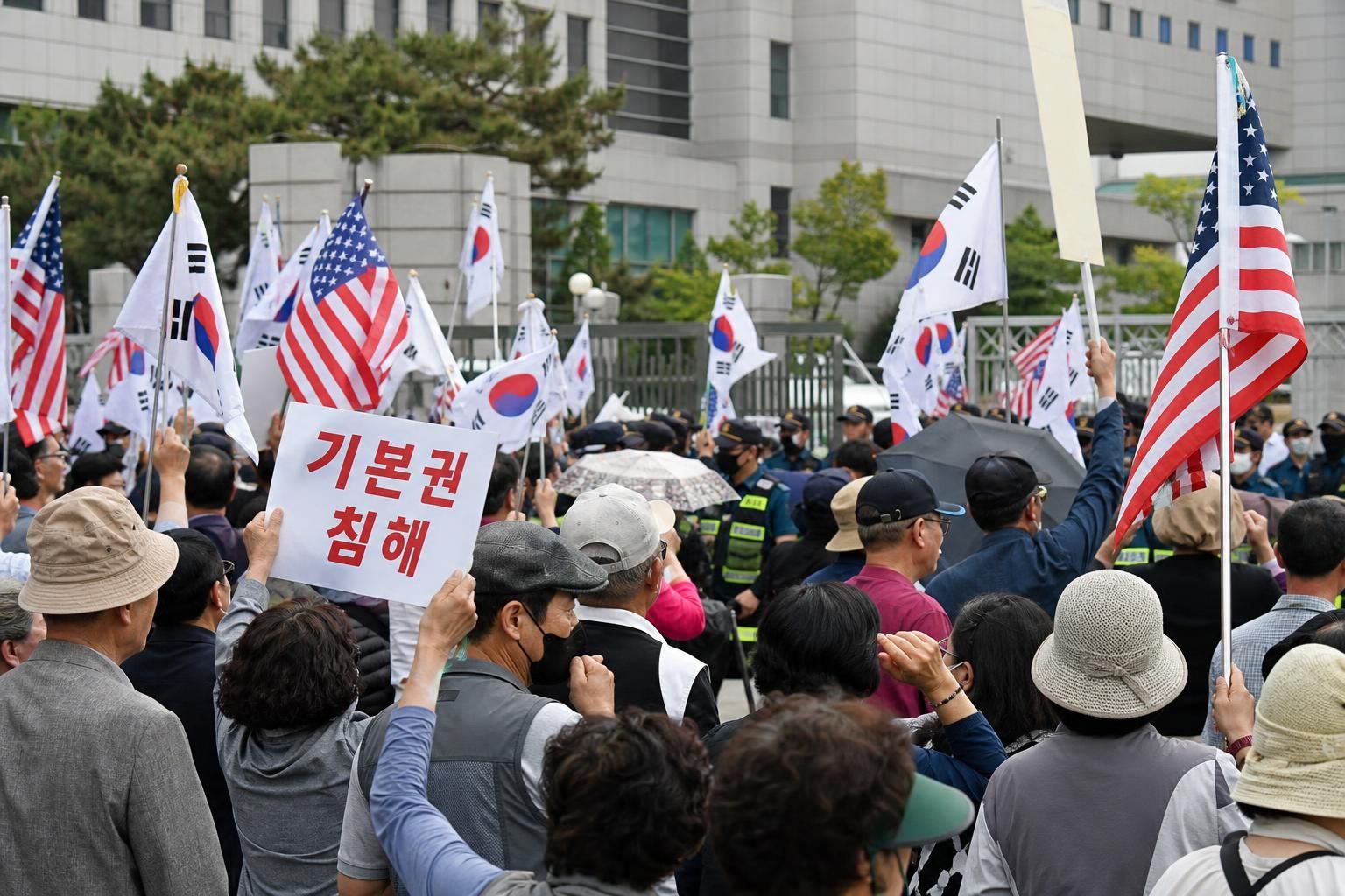 투표용지, 선거관리위원회, 재선거 기사 핵심 맥락을 보여주는 이미지 - 부산 집회는 전날부터 이어진 움직임의 연장선이다. 이날 오후 부산시선관위 앞에는 성조기와 태극기를 흔든 참가자들이 있었고, 피켓에는 ‘기본권 침...