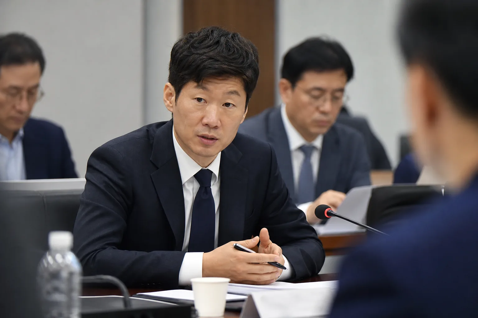 축구장과 회의실을 배경으로 한 한국 축구 개혁 논의 이미지