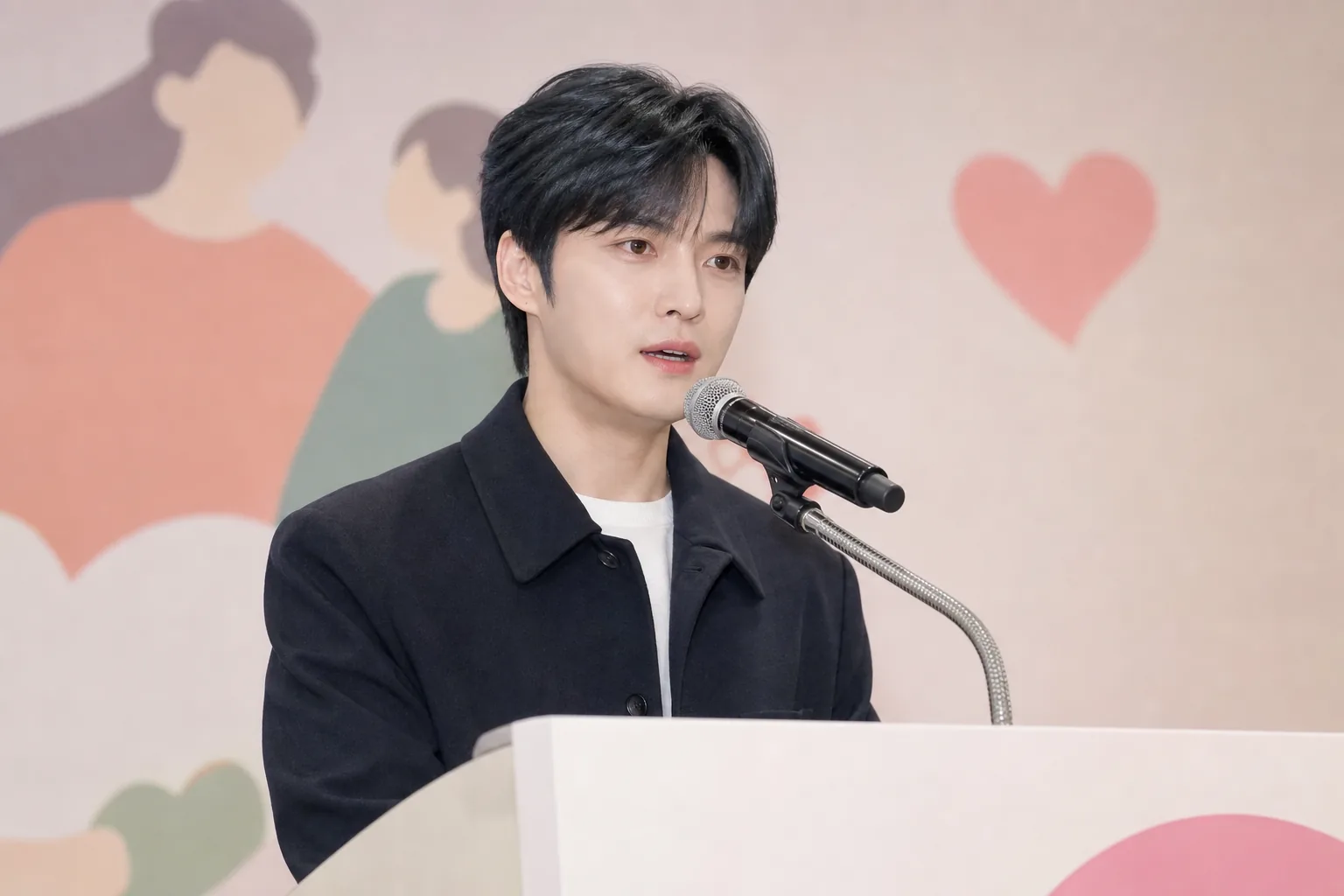 기념식 무대에서 가족과 새로운 시작을 응원하는 연설 장면