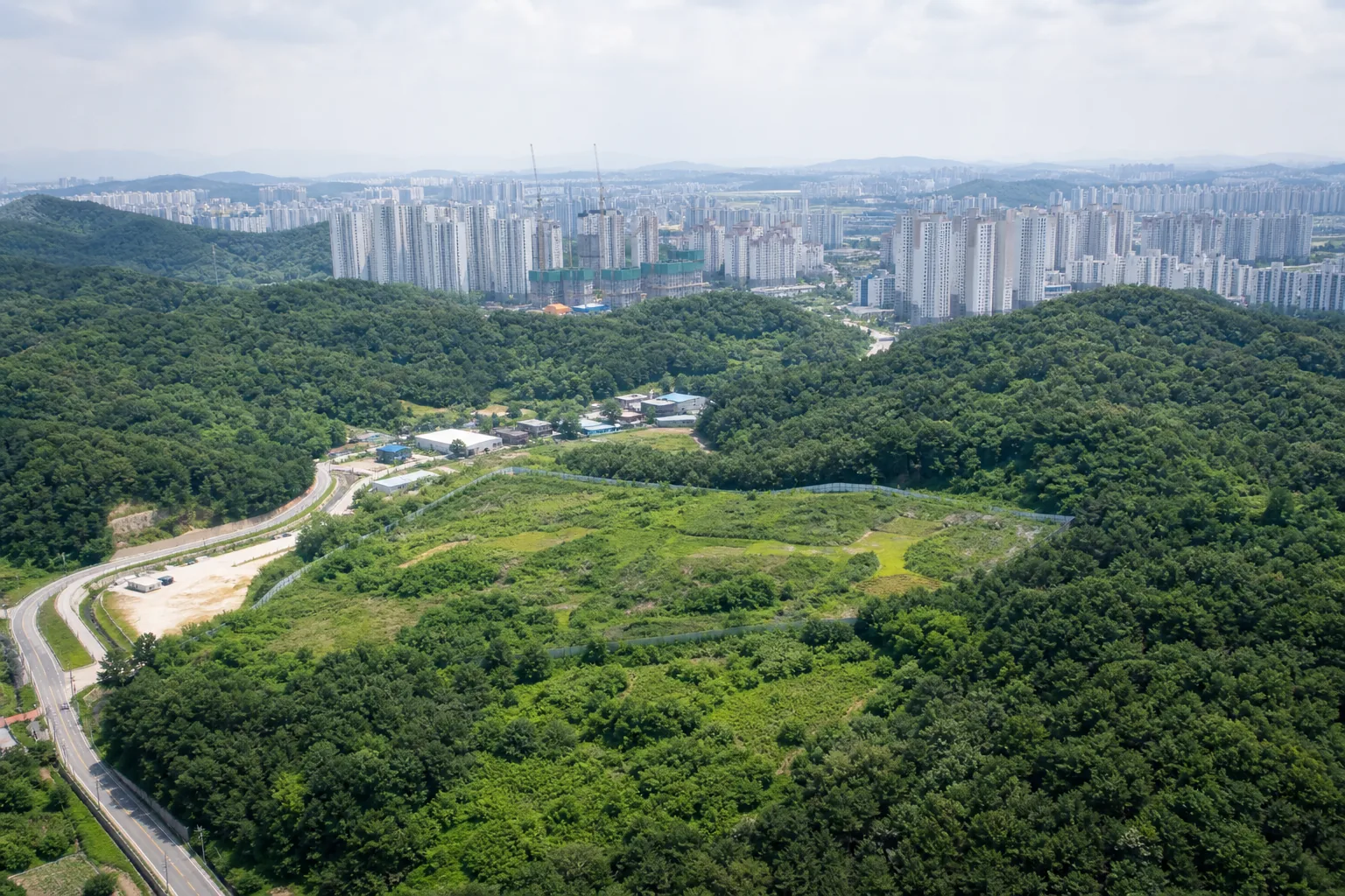 도시 외곽 녹지와 주택 개발 예정지를 바라보는 모습