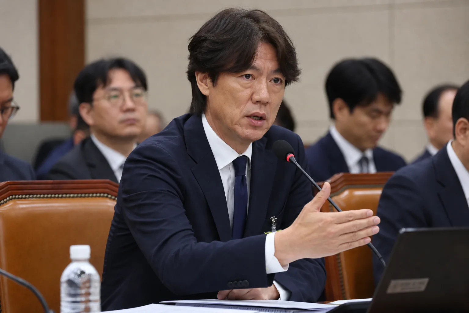 축구장 현장에서 지도자와 행정 관계자가 논의하는 장면