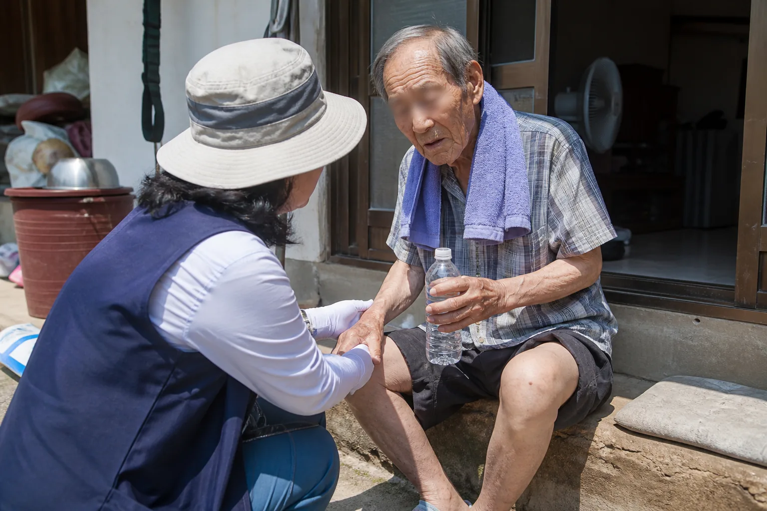 보건소 방문간호사가 어르신의 혈압과 건강 상태를 확인하는 모습